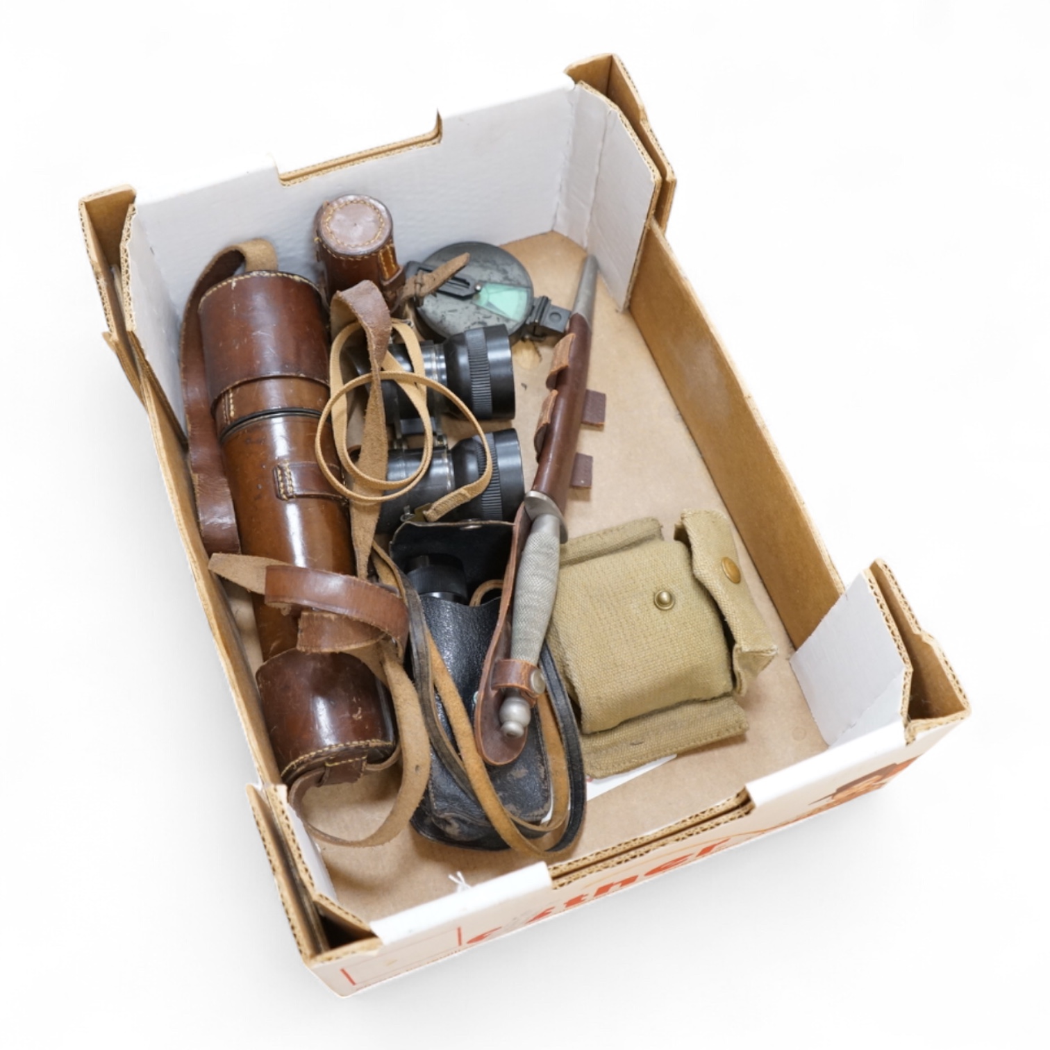 A Sykes-Fairburn Fighting Knife by Wilkinson sword in its leather scabbard, together with a 1942 Mk.III military compass by T.G.Co.Ltd. in a webbing pouch dated 1940, together with another compass, a telescope in a leath